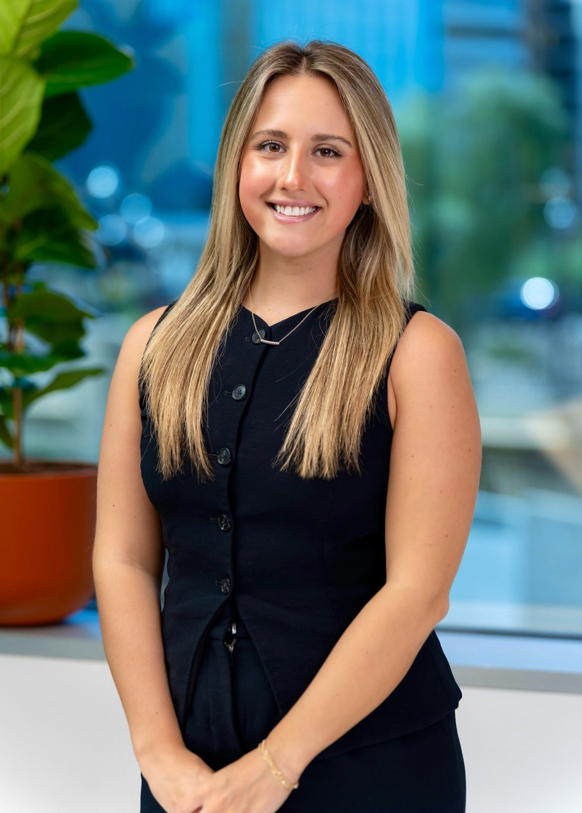 On-location corporate headshot photographed in Basata's Tempe conference room, with the office's blue wall graphic out of focus behind