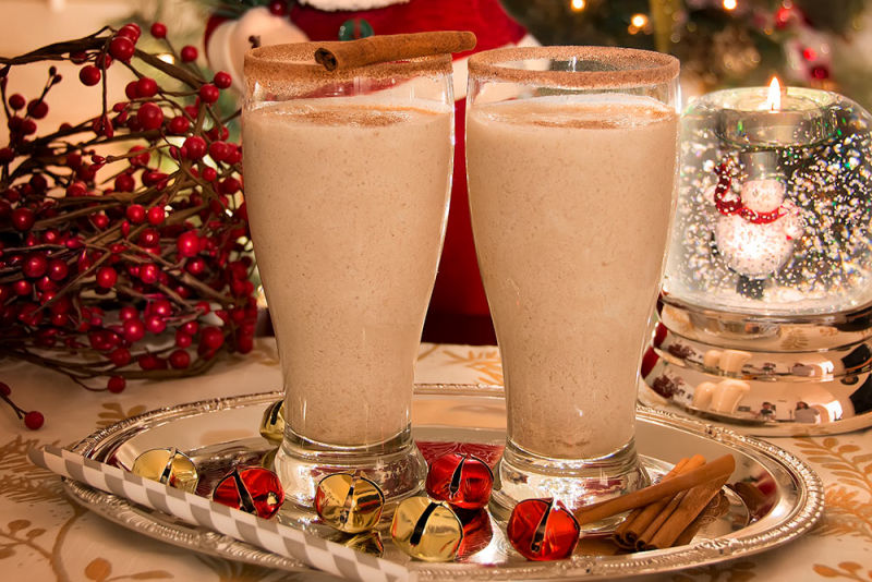 Tasty Christmas milk shakes made with cinnamon on a chrome platter with decorations