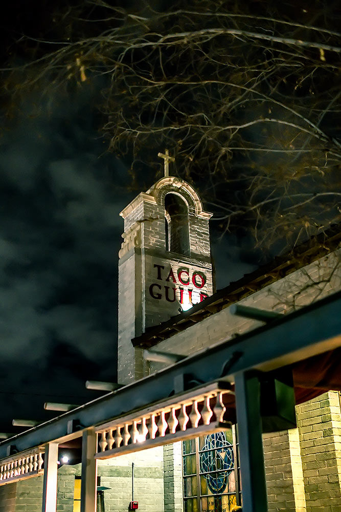 Iconic Taco Guild with striking cross silhouette against a captivating nocturnal sky