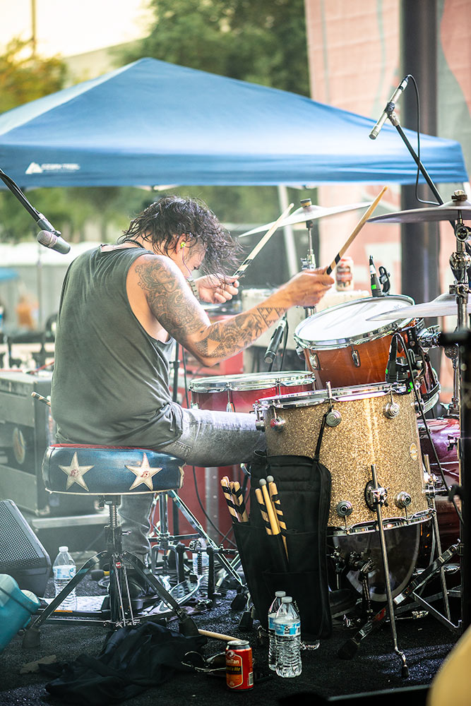 A drummer performing a solo during a hot summer performance