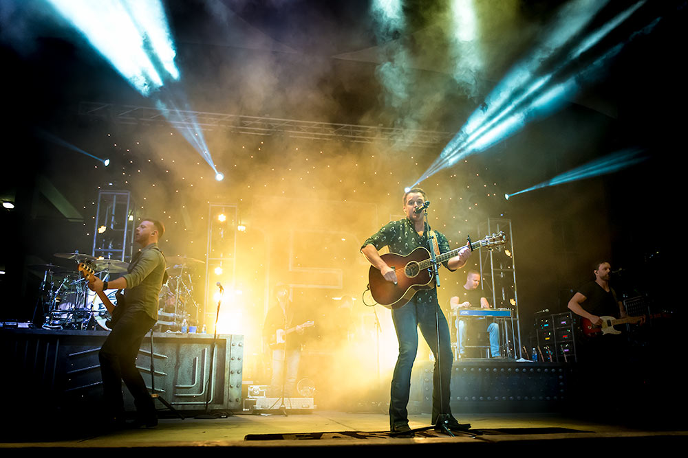 Easton Corbin on Tour playing in front of a yellow halo light
