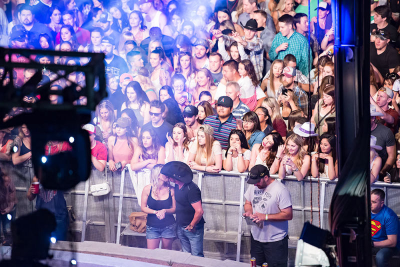 Sneak peek of a couple kissing during a country concert