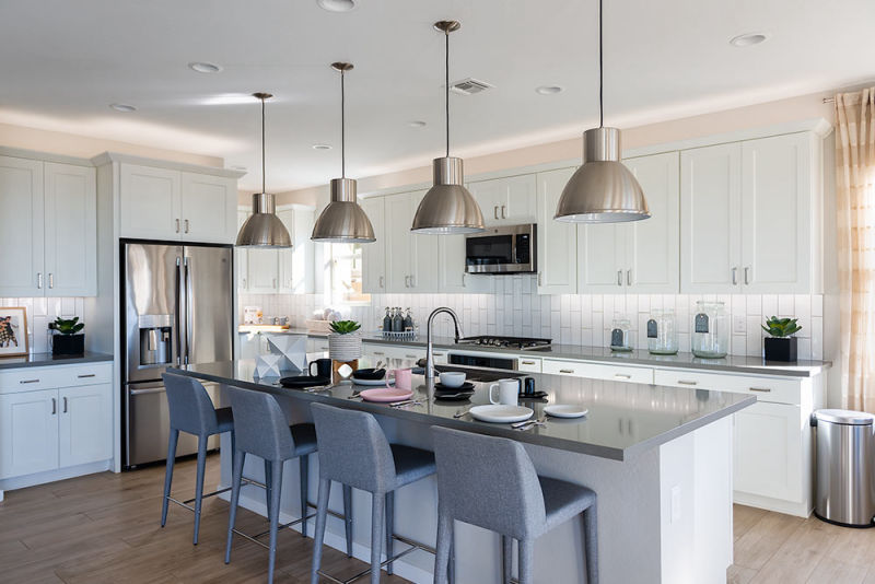 Contemporary and well-lit white kitchen featuring exquisite HF Coors plates complementing the model of Shea Homes