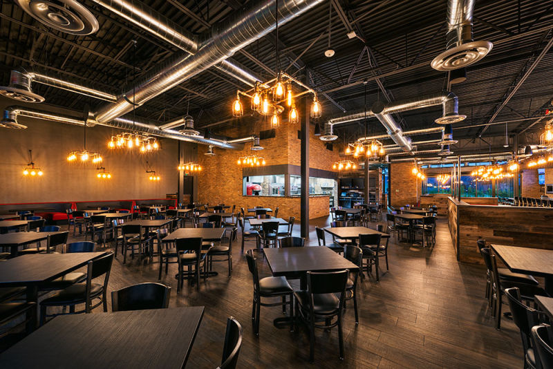 Phoenix, AZ restaurant aglow in golden hour light, with warm ambience, glowing lights, and inviting brown tables