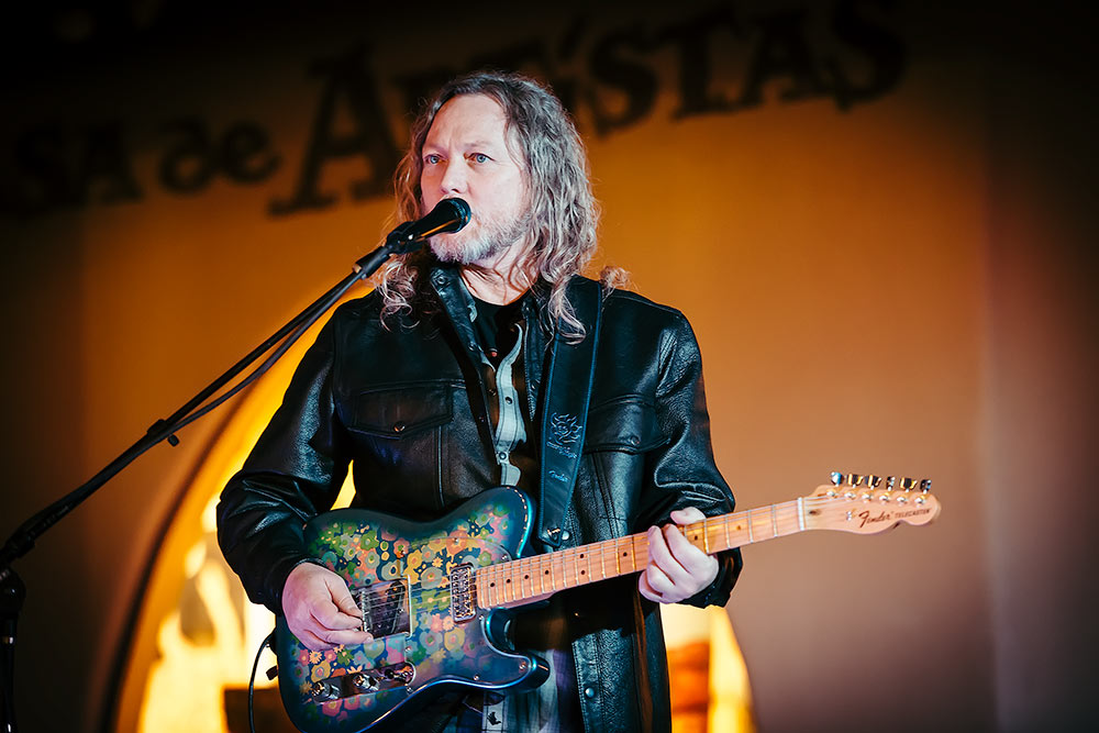 A lead guitarist playing a colorful Fender