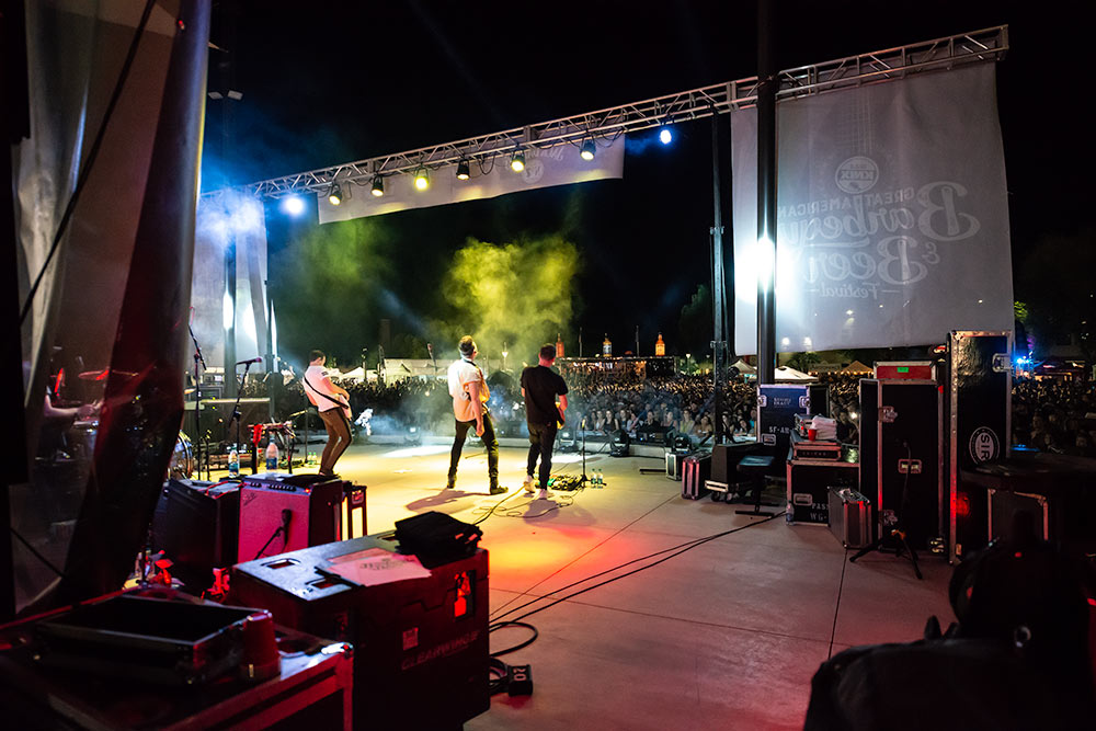 A sneaky view of a backstage performance while the band plays in front of a crowd