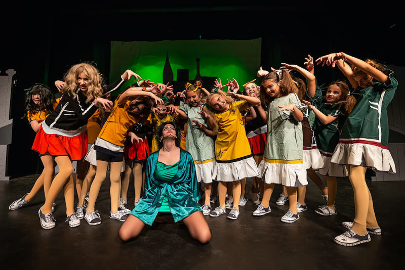 Cast of Annie on stage hissing at Miss Hannigan