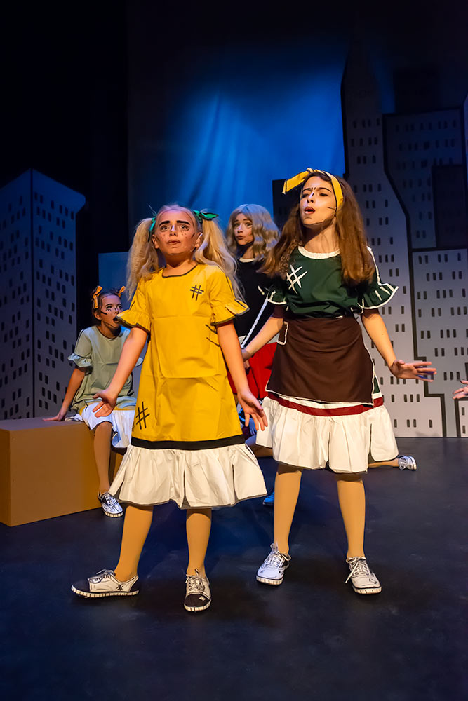 Young ladies dressed as orphans during a stage performance