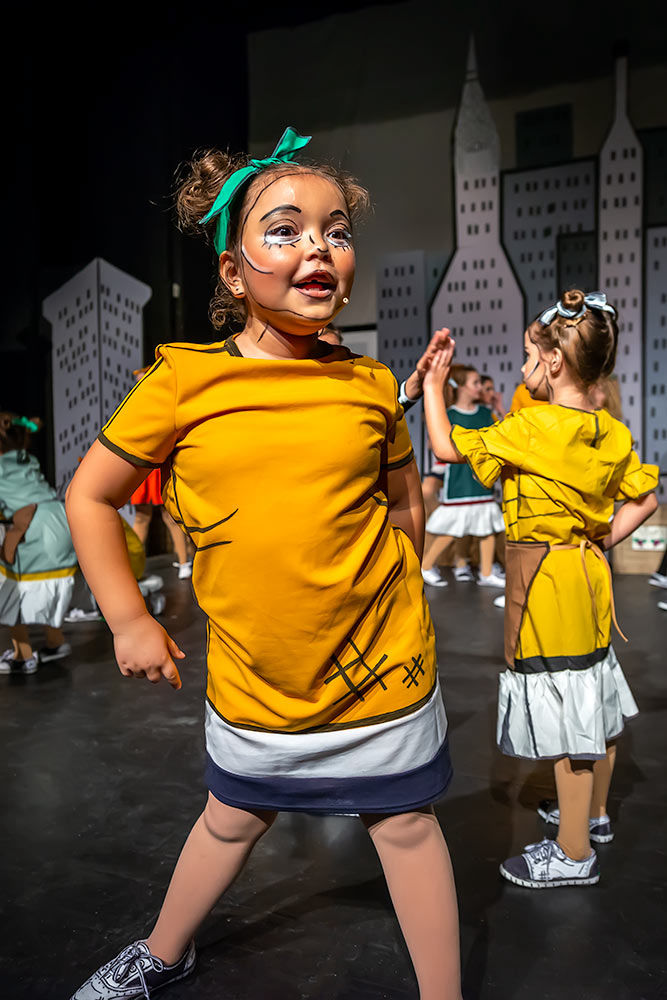 Molly in a yellow dress from Annie belting out a line