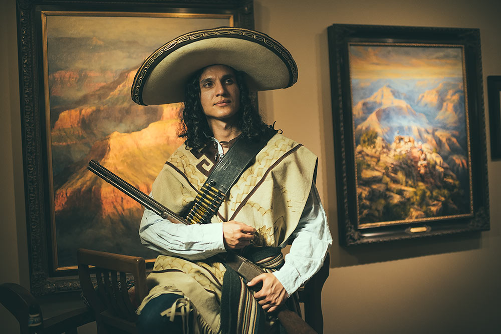 A life pose for a painter inside of a gallery with western style paintings on the wall in Scottsdale Arizona