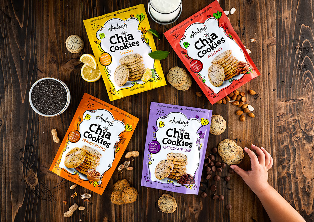 Audrey's Chia Cookies advertisement with 4 offerings and a little girls hand grabbing one of the cookies