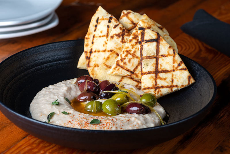 Hummus dip with tortilla chips under natural light