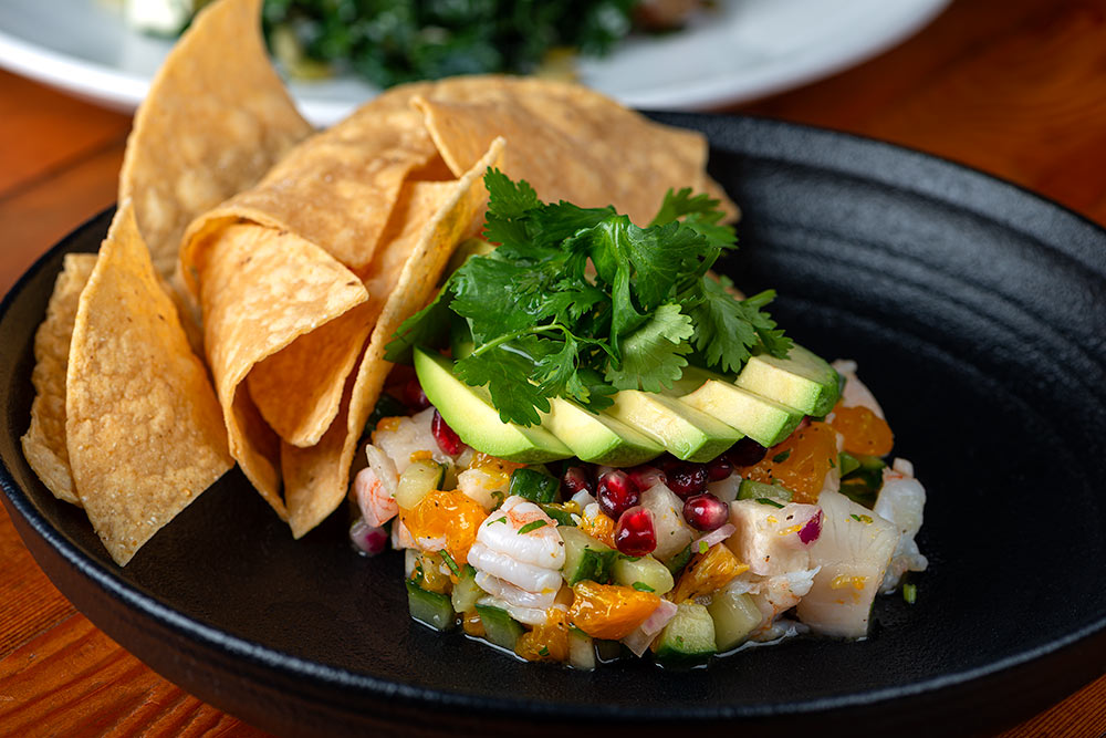 A vegetable dip with many types of veggies and a side of chips