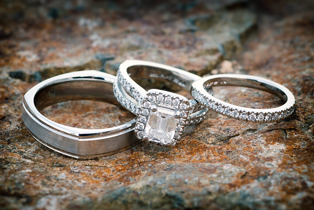 Wedding rings with diamonds sitting on old rocks