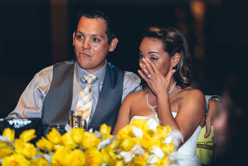 A sad bride wipes away a tear while listening to speeches