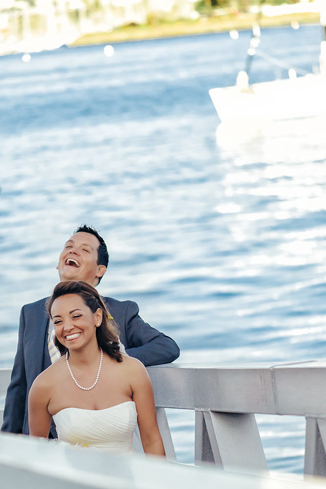 A sneak shot of a just-married couple on a pier having a moment