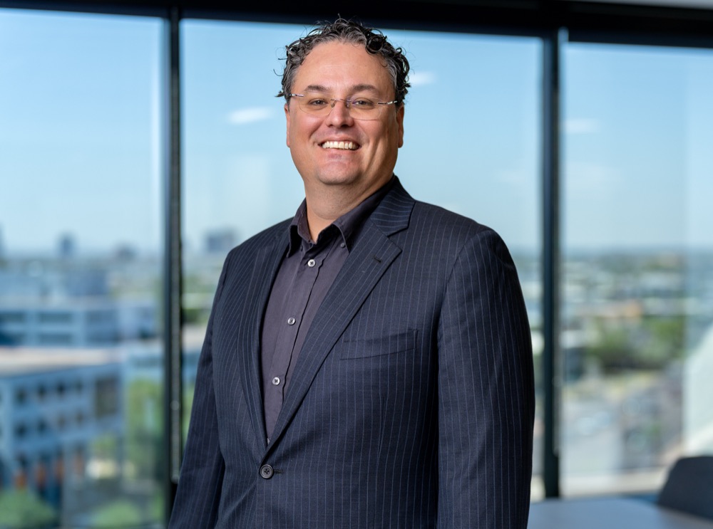 Executive headshot photographed against office windows in Phoenix, Arizona — photo 8