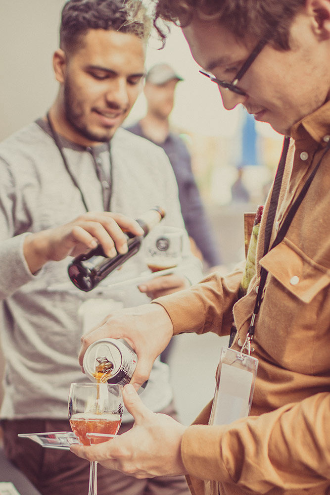 Pouring of a beer sampler with 2 guys at an event