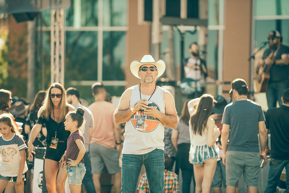 A cowboy watching a band play