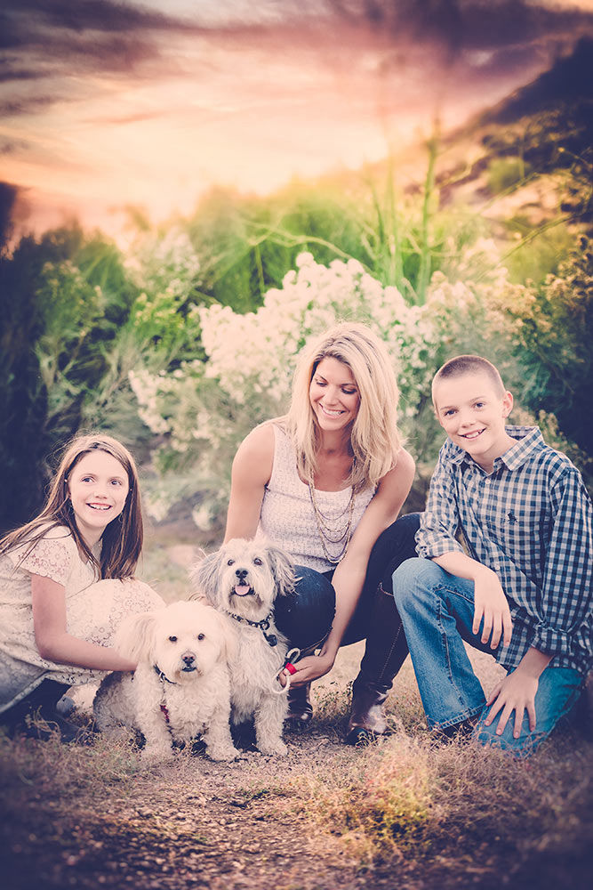 A family in the desert with their little dogs during sunset hour