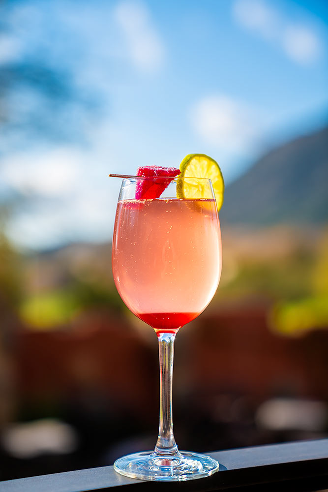Wonderful fruity cocktail with lemon top over a desert background at sunset