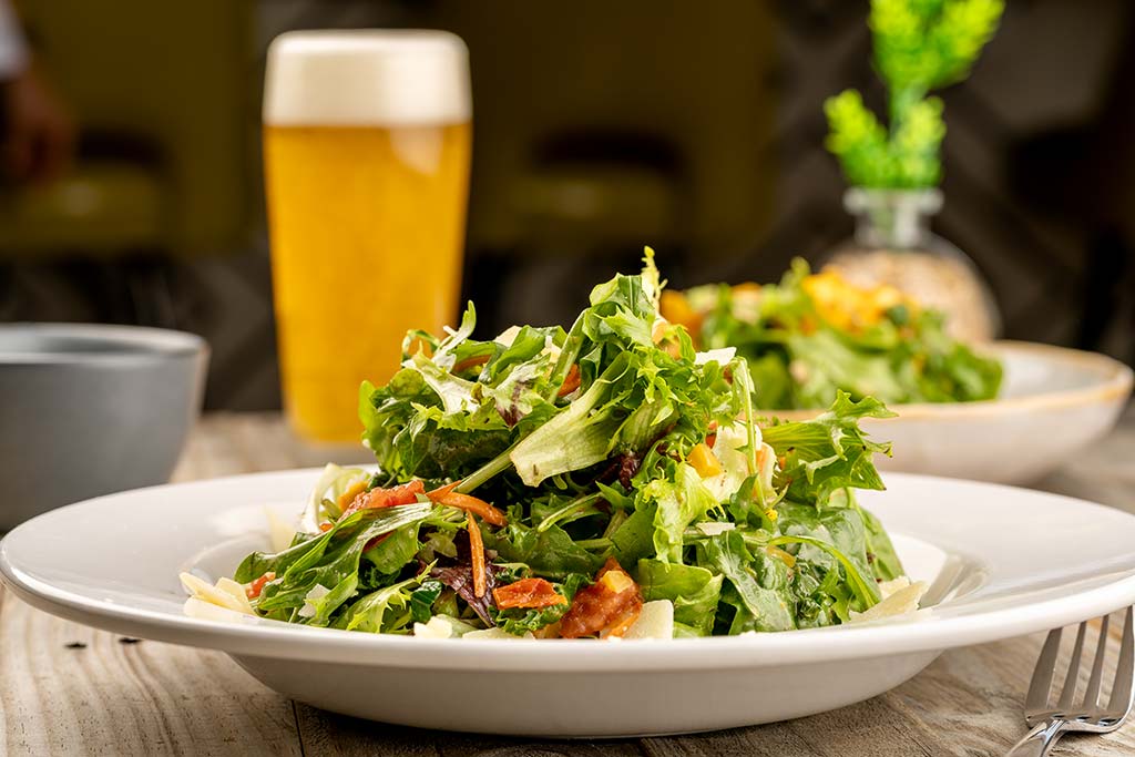 Well-presented salad paired with a refreshing beer at Hundred Mile Brewing restaurant in Tempe, AZ