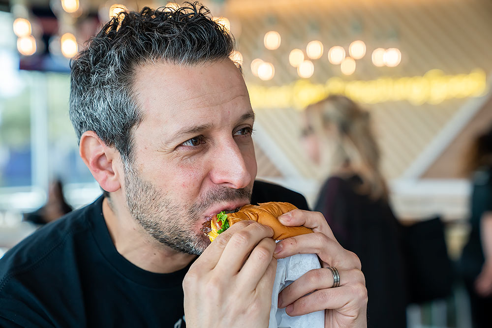 Lifestyle photo man eating hamburger