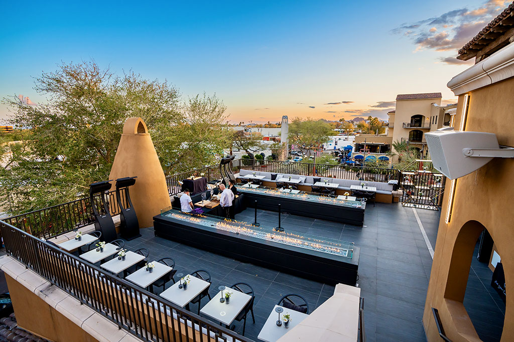 Scenic view of STK Steakhouse's new patio Rooftop Space, with a breathtaking sunset sky backdrop