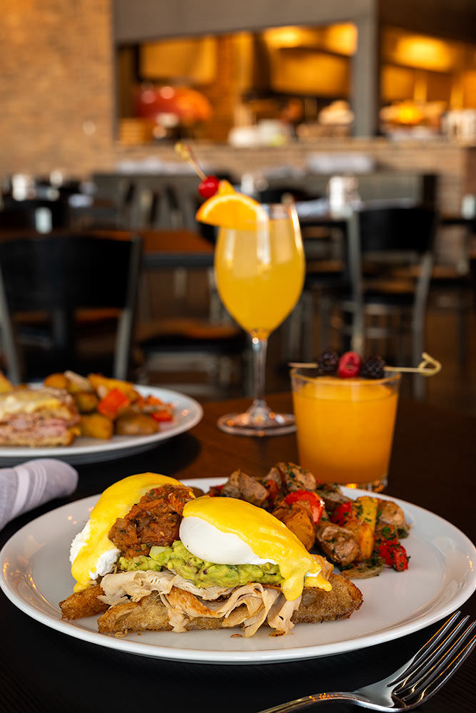 A brunch meal with a mimosa with fruit inside of a restaurant