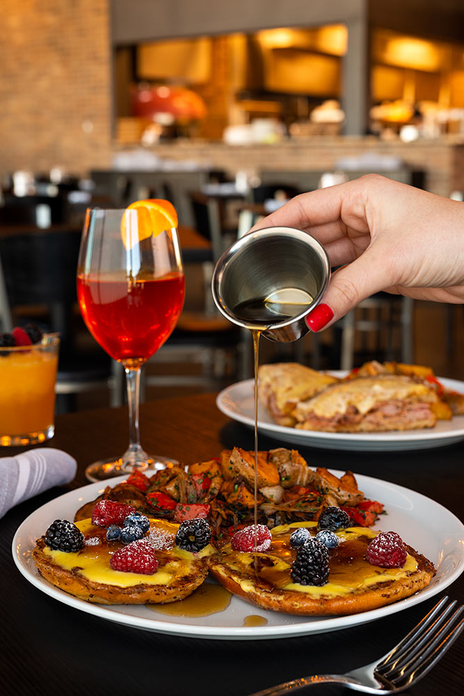 Pouring syrup over breakfast platter