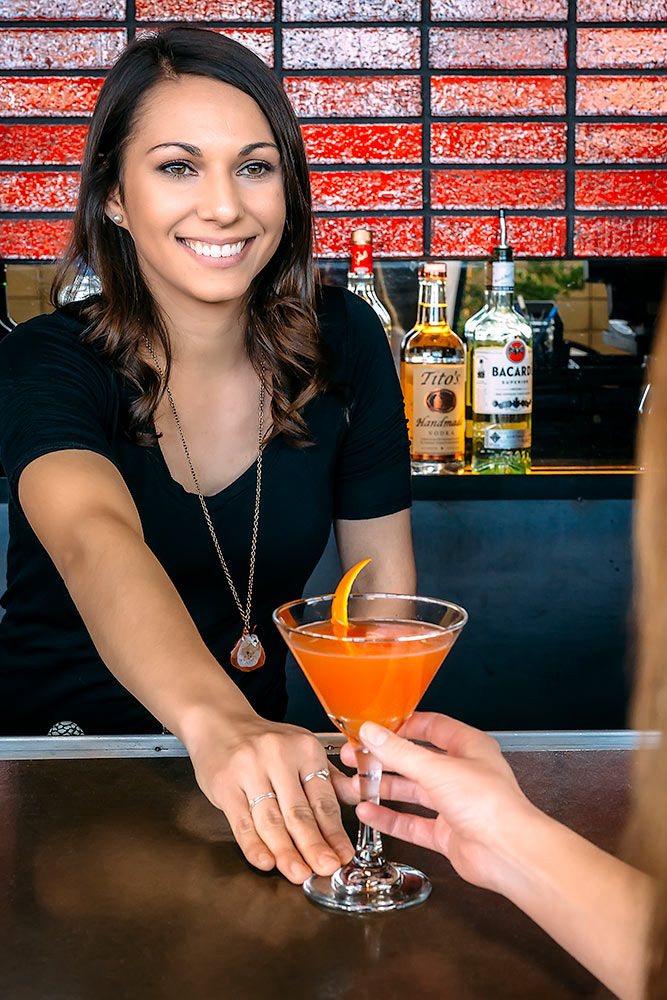 Bartender handing off a cocktail